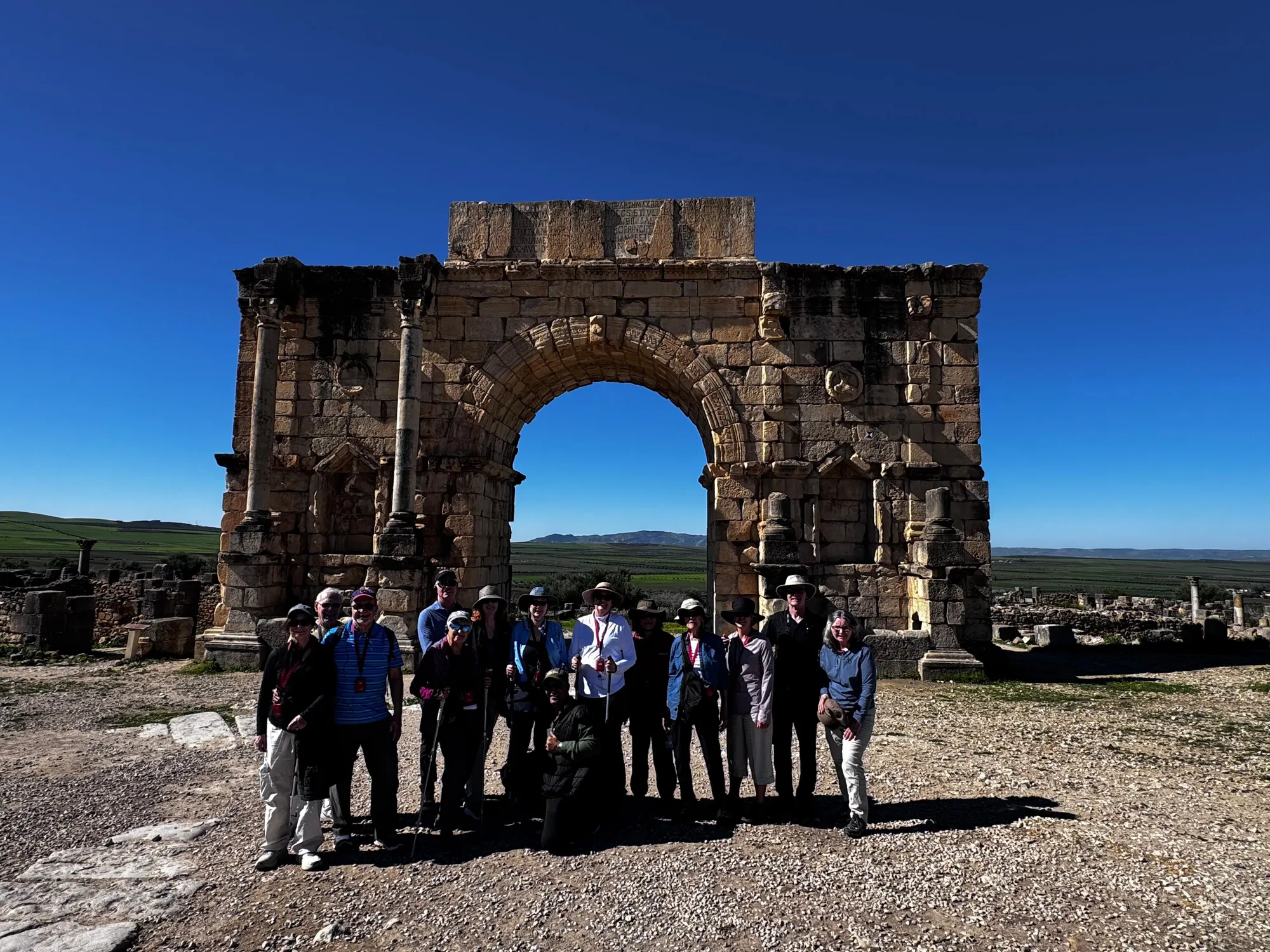 Travelers beneath the Roman arch at Volubilis